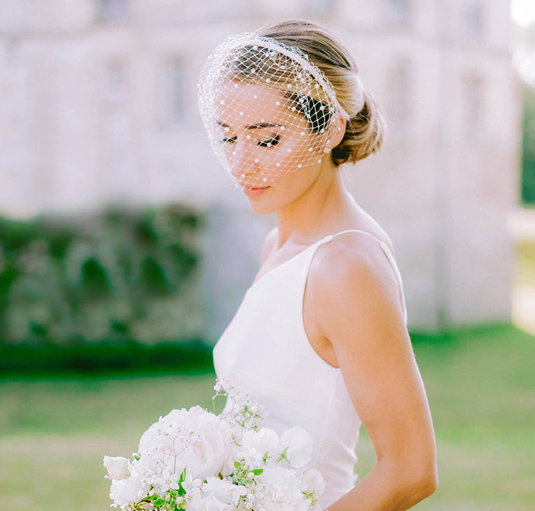 Une mariée pose pour la photos avec son bouquet